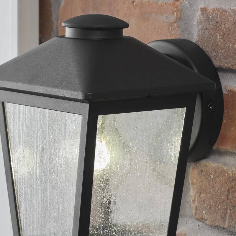 Luz de pared exterior con un candelero Hampton Bay Malena de 7.83 pulgadas y 1 luz en color negro con cableado duro y cristal claro con semillas - 5294503012