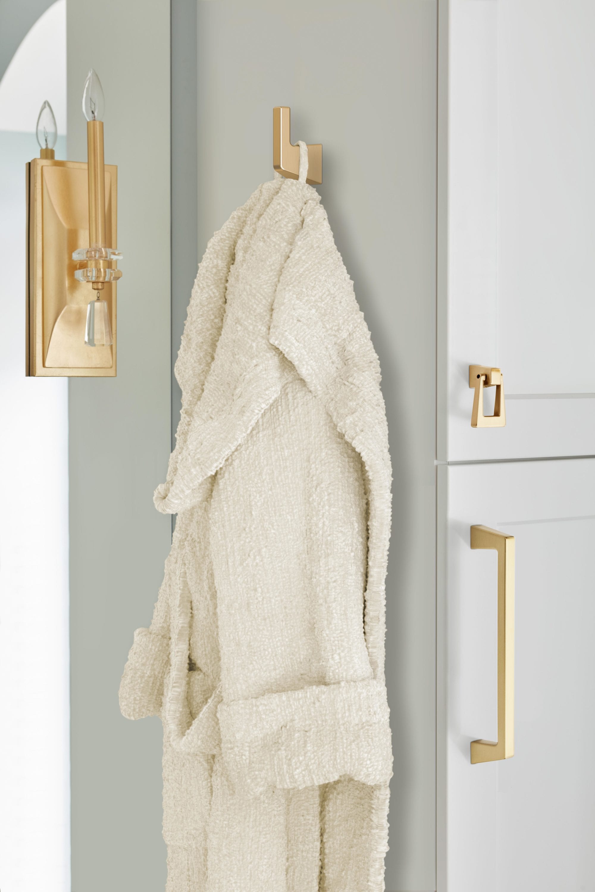 Percha para toallas de montaje en pared con un solo gancho en bronce champagne de la línea Blackrock de Amerock